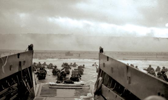 During Operation Neptune, GIs wade ashore on Normandy’s Omaha Beach.